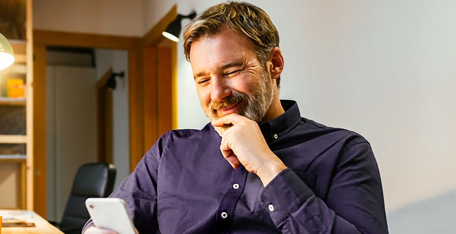 man-smiling-at-phone.jpg